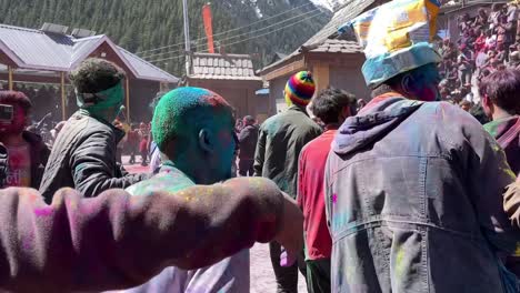 Group-Of-People-Gathered-Outside-The-Temple-Celebrating-Holi-Festival-Dancing-And-Spreading-Colorful-Dry-Powder-In-Sangla-Village-In-Kinnaur-Valley,-Himachal-Pradesh,-India