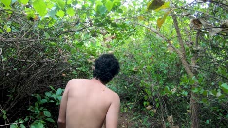 Back-View-Of-A-Shirtless-Guy-Walking-On-The-Forest-Trail-In-The-Lush-Hill-In-Maharashtra,-India---medium-slowmo-shot