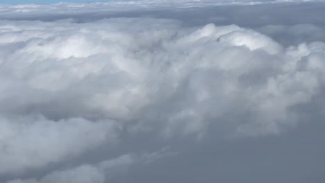 Weiße,-Dicke-Wolken-über-Den-Bergen-Des-Himalaya,-Aus-Dem-Fenster-Eines-Fliegenden-Flugzeugs-Betrachtet