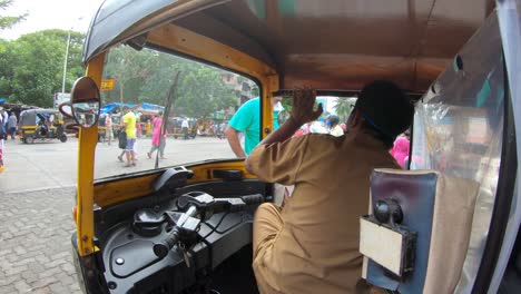 Tuk-tuk-Driver-Talking-With-A-Man-While-Waiting-For-Passengers-In-Mumbai,-India---slow-motion