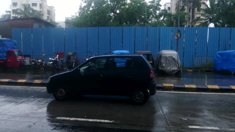 Cámara-Lenta-De-Vehículos-Que-Pasan-Por-La-Carretera-Asfaltada-En-Mumbai,-India,-Bajo-La-Lluvia---Toma-Panorámica