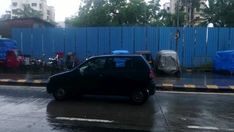 Slow-Motion-Of-Vehicles-Passing-By-On-The-Asphalt-Road-In-Mumbai,-India-Under-The-Rain---panning-shot