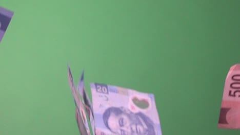 Slow-motion-shot-of-Mexican-Peso-notes-falling-slowly-against-a-green-screen