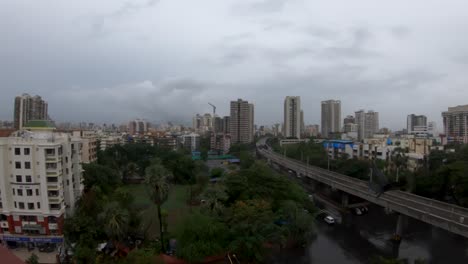 Vermummte-Luftlinie-Fliegt-Von-Einem-Gebäude,-Das-An-Einer-Eisenbahnlinie-Mit-Stadtbild-Im-Hintergrund-In-Mumbai,-Indien,-Vorbeifährt