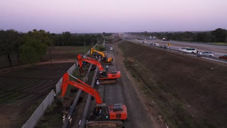 Camiones-Excavadoras-Estacionados-E-Ingenieros-Que-Trabajan-En-Un-Sitio-De-Construcción-De-Tuberías,-Al-Lado-De-La-Vía-Pública