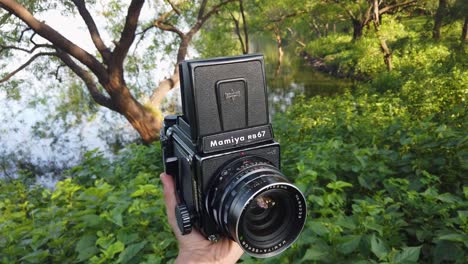 Hand-Holding-And-Showing-Mamiya-RB67,-Professional-Medium-Format-Single-lens-Reflex-System-Camera