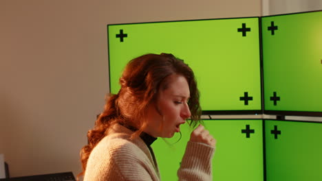 -Young-caucasian-woman,-sick,-multiple-green-screen-computer-monitors-with-tracking
