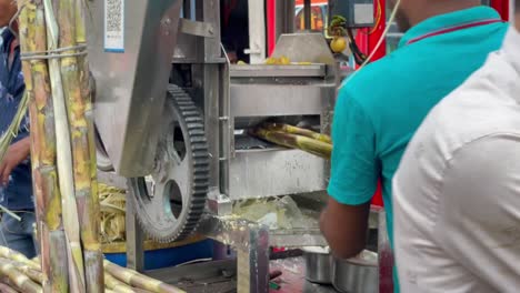 Hombre-Indio-Haciendo-Jugo-De-Caña-De-Azúcar-Fresco-Con-Máquina-De-Jugo-De-Caña-De-Azúcar-En-Trimbakeshwar,-India