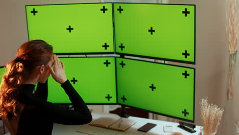 -Young-woman,-multiple-green-screen-computer-monitors-with-tracking