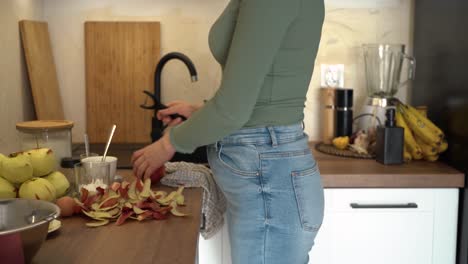 The-woman-is-peeling-an-apple-over-the-countertop