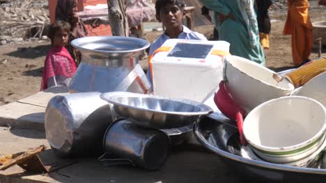 Montón-De-Tazones-De-Metal,-Vasos-Para-Beber-En-La-Mesa-Afuera-En-El-Campamento-Para-Las-Víctimas-De-Las-Inundaciones-En-Sindh