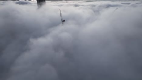 Aerial-shot-above-a-cloudy-foggy-Brisbane-City,-with-only-the-tops-of-sky-scrapers-being-visible