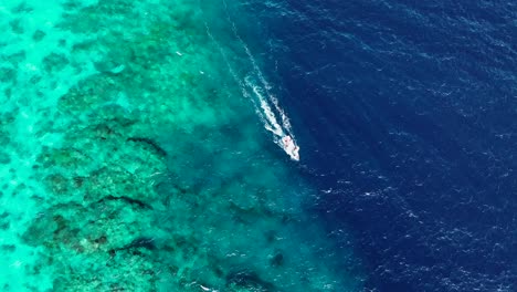 Cruising-Boat-Leaving-Wake-On-Blue-Sea-With-Beautiful-Coral-Reefs-Underwater