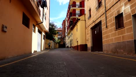 Vista-Trasera-De-Mujer-Caminando-En-Zona-Residencial-En-Aranda-De-Duero,-Burgos