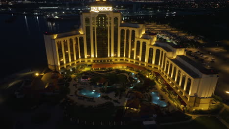 Drone-shot-around-the-pool-area-in-front-of-the-L'Auberge-Casino-and-Hotel,-night-in-Lake-Charles,-Louisiana,-USA