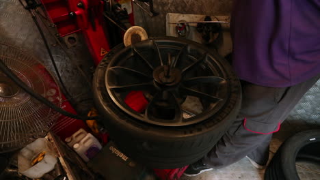 Slow-motion-shot-of-a-tyre-fitter-using-a-machine-to-put-on-a-new-tyre
