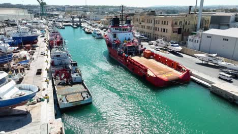 Drone-aerial-shot-flying-over-several-ships-in-a-boat-yard-and-towards-a-tug-boat