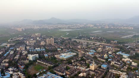 Vista-Panorámica-De-La-Ciudad-De-Vasai-En-Un-Día-Brumoso-Cerca-De-Los-Suburbios-Occidentales-De-Mumbai,-India---Toma-Aérea-De-Drones