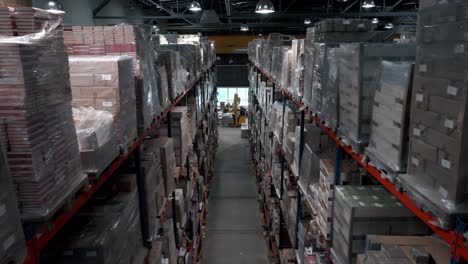 Inside-of-large-full-warehouse,-pallets-of-cardboard-boxes-ready-for-shipment