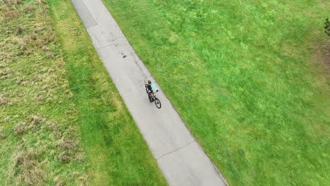 Freestyle-Cyclist-Riding-Bicycle-on-One-Wheel,-Drone-Aerial-View
