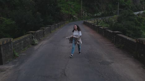 Vista-De-Drones-De-Una-Mujer-Caminando-En-El-Viejo-Puente-En-La-Isla-De-Madeira,-Portugal