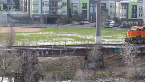 BNSF-locomotive-move-slowly-on-bridge-through-residential-area,-Denver-Colorado