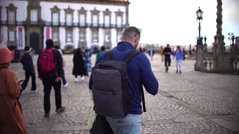 Porto,-Portugal,-March-26,-2023:-Tourist-man-walking-though-Porto-streets-at-famous-square-in-Portugal