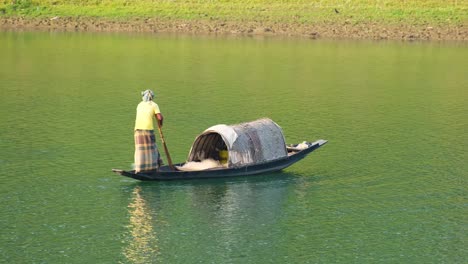 Pescador-Tradicional-Bangladesí-En-Barco-Sampán-Lanzando-La-Red-De-Pesca.