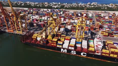 Aerial-View-Of-Container-Ship-In-Loading---Unloading-Logistics-Terminal-Of-Manzanillo,-Colima,-Mexico---drone-shot