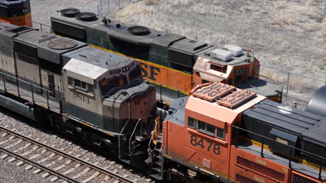 Der-BNSF-Zug-Fährt-An-Statischen-Lokomotiven-Auf-Der-Eisenbahn-Vorbei,-Denver,-Colorado