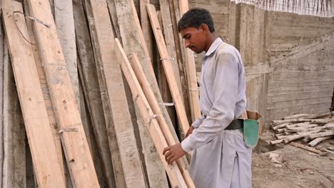 Trabajador-Paquistaní-Usando-Un-Martillo-Para-Partir-Madera-En-El-Sitio-De-Construcción
