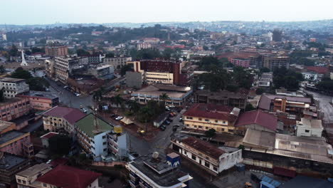 Aerial-reverse-drone-shot-over-the-cityscape-of-downtown-Yaounde,-in-rainy-Cameroon,-Africa