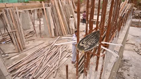 View-Of-Labourers-Working-On-Construction-Site-With-Wooden-Timber-And-Bamboo-On-The-Floor-In-Karachi