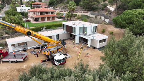 Aerial-view-over-treetops-to-modular-house-assembling-project-on-busy-property-development-construction-site