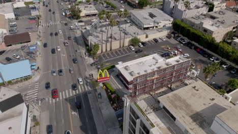 Cars-drive-through-bustling-intersection-in-downtown-Los-Angeles-during-midday