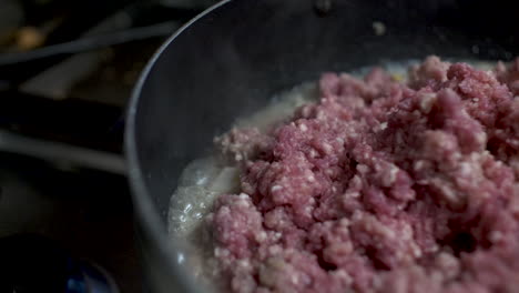 Close-Up-Shot-Of-Sizzling-Oil-Bubbling-Around-Pan-Cooking-Raw-Mince-Beef