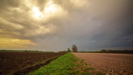 Dark-thunderstorm-clouds-starts-to-flow-above-agriculture-landscape,-time-lapse
