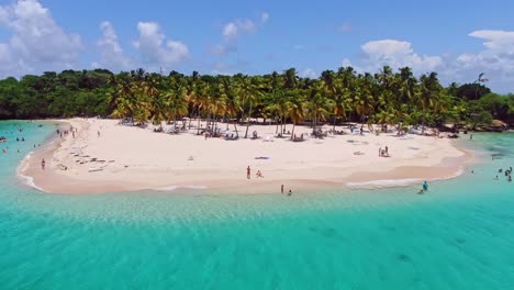People-relaxing-on-white-sandy-beach-and-in-tropical-waters-of-Cayo-Levantado-or-Bacardi-island,-Samana-in-Dominican-Republic