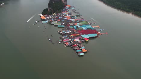 Aerial-tilt-shot-overlooking-the-Koh-Panyee-town,-in-cloudy-Phang-Nga-Bay,-Thailand