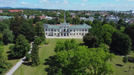 Drone-Shot-approaching-an-old-Palace-surrounded-by-a-green-Park