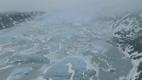 Aerial-View-of-Glacier,-Frozen-Glacial-Lake-and-Icebergs-on-Foggy-Spring-Morning-in-Highlands-of-Iceland