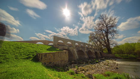 Sunshine-and-historical-bridge-of-Pakruojis-manor,-time-lapse-view