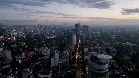 Aerial-view-overlooking-the-Reforma-avenue,-vibrant-dusk-in-Mexico-city
