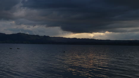 Enten-Am-Lake-Rotorua-Mit-Sonne,-Die-Durch-Wolken-Strahlt