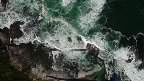 Top-Down-Drone-View-of-Tidal-and-rocks,-with-waves-breaking