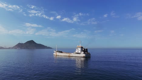 Cargo-Ship-Floating-In-The-Calm-Blue-Waters-of-Sea-In-Daytime