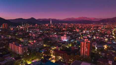 Panoramic-Aerial-Hyperlapse-Fly-Above-Barrio-Italia-Santiago,-Chile-at-Sunset-Time,-City-Neighborhood,-Andean-Cordillera-and-Architecture-with-Vibrant-Blue-and-Pink-Tones