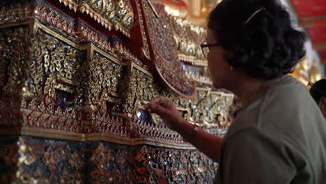 Artesano-Cualificado-Que-Trabaja-Para-Reparar-La-Decoración-Ornamental-En-El-Templo-Budista-Tailandés,-Utilizando-Herramientas-Finas-Y-Pintura-Dorada