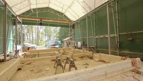 Wide-shot-of-timber-frame-for-log-cabin-being-assembled-in-workshop