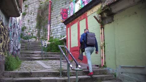 Porto,-Portugal,-March-26,-2023:-Tourist-man-walking-though-poor-neiborhood-narrow-streets-where-poverty-can-be-seen-in-Oporto,-Portugal